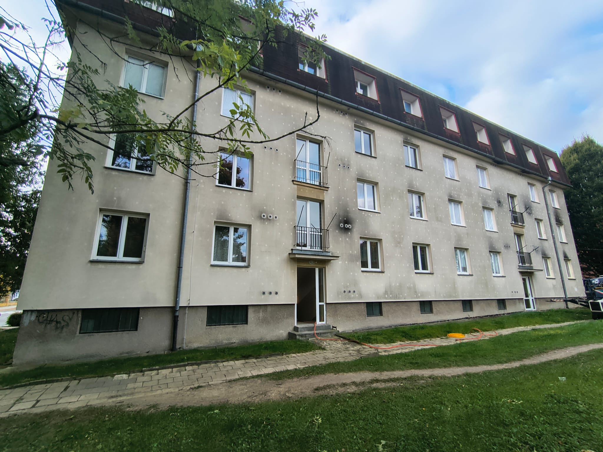 Bytový dům se zašlou špinavou fasádou před čištěním